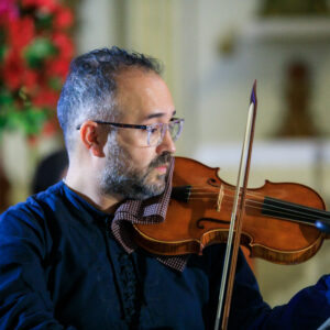 2023 premier orchestral institute's composer competition winner Federico Hoyos in close up playing violin.